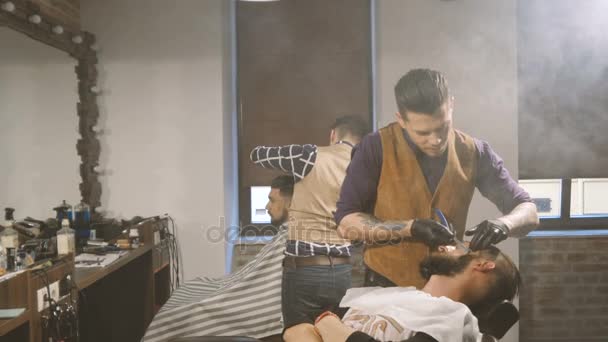 Proceso de afeitado de barbas en la barbería. Master hace un cliente de barba de corte de pelo con navaja de afeitar vintage . — Vídeo de stock