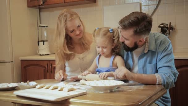 幸せな家族の母、父とテストからパイを作って台所で小さな娘. — ストック動画