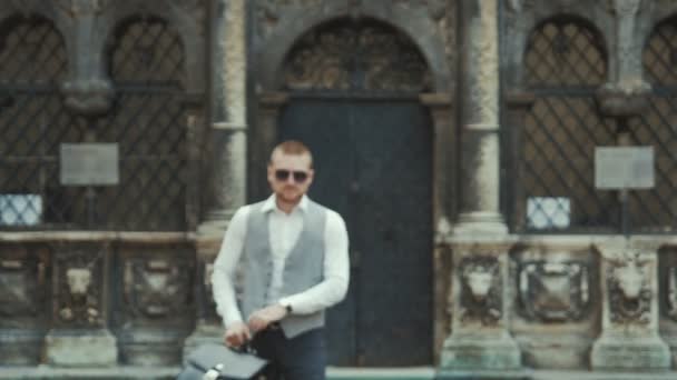 Hombre en traje gris clásico con maletín al aire libre — Vídeos de Stock