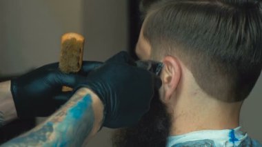 Bir kuaföre tıraş olan bir adam..