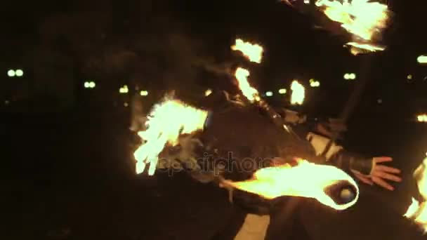 Fire show performance. Handsome male fire juggler performing contact manipulation with fire baton with several wicks dragon staff. Close-up. Slow motion — Stock Video