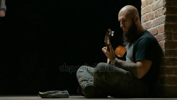 젊은 남자 기타 연주 단계에 앉아 — 비디오