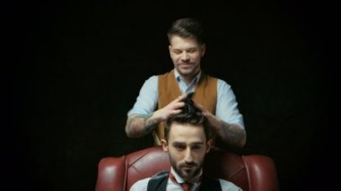Genç yakışıklı Kuaför berber içinde çekici adamın saç kesimi yapma
