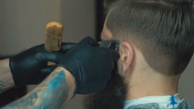 Beyaz gömlek, izle ve istemci için bir saç kesimi makas kuaför dükkanında işi siyah eldiven giymiş siyah saçlı çekici Kuaför,