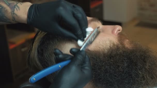 Barbeiro cortando barbudo homem brutal, salão de barbearia — Vídeo de Stock