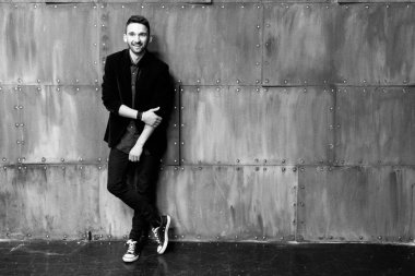 Duvarın yanında spor ayakkabı adam. siyah beyaz fotoğraf