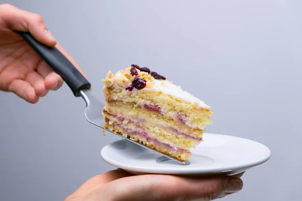 Chef lays out a cake on a plate, dessert presentation. Close-up.