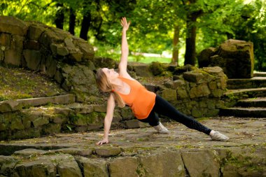 sabah, yaşam tarzı spor insanlar kavramı yeşil güneşli Park yoga yaparken genç sarışın kız