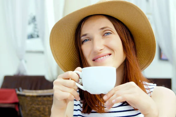 Portrait d'une jeune femme brune assise et buvant du thé — Photo