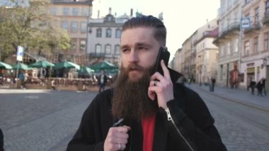 Genç sakallı adam portresi mutlu erkek arkadaşıyla telefonda konuşurken heyecanlı