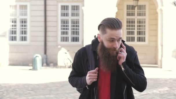 Retrato de un joven barbudo emocionado hombre feliz hablando con un amigo por teléfono — Vídeos de Stock