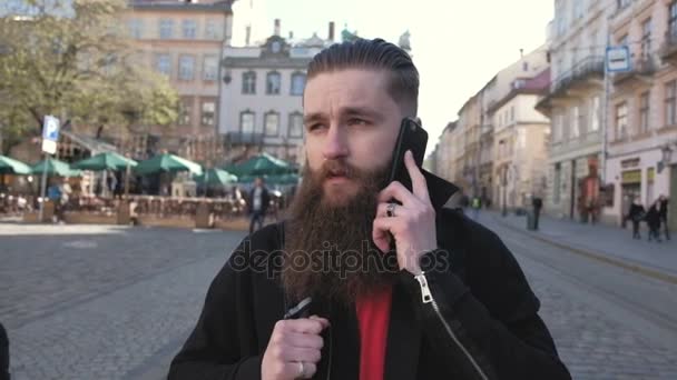 Ritratto di giovane uomo barbuto eccitato uomo felice che parla con un amico al telefono — Video Stock