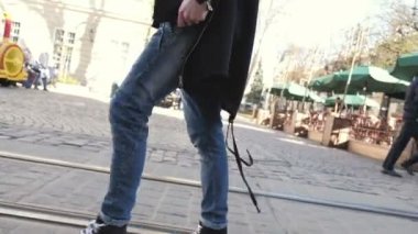 Sokakta bir gömlek ve siyah bir ceket giyen sakallı koyu saçlı genç çekici neşeli adam. Erkek sokak stili. Bahar doğa. Şehirde yürüyüş.