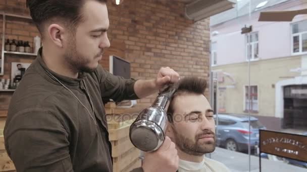 Barbeiro hábil secagem cabelo masculino na barbearia — Vídeo de Stock