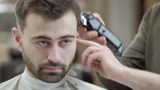 マスター カット髪し理髪店で男性のひげ、美容師は若い男の髪型 — ストック動画