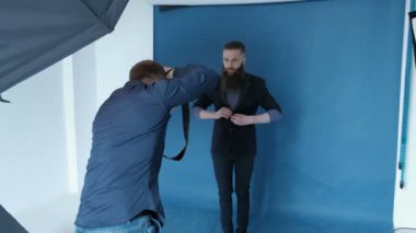 Fotoğrafçı Studio mavi arka plan ile man modeli için fotoğraf çekmek. Uzun sakallı adam modeli. Moda katalog çekim