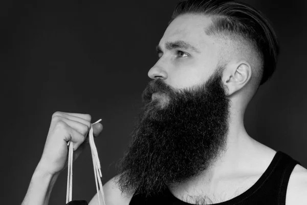 Perfil preto e branco do homem barbudo. Mãos segurando tênis . — Fotografia de Stock