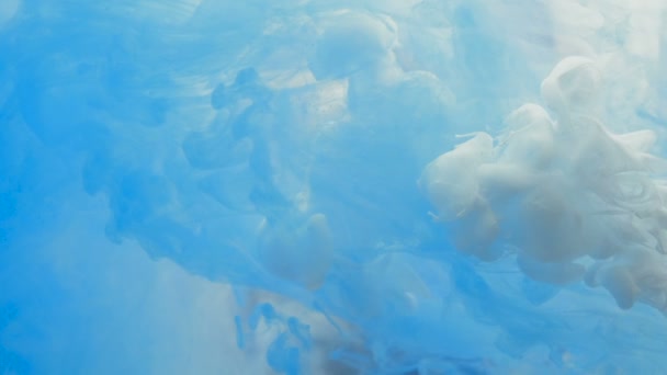 Encre bleue et blanche tombée dans l'eau sur fond blanc prise de vue avec caméra haute vitesse ,