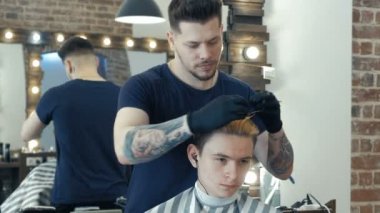 Genç adam, genç, Güzellik Salonu. Saç stili oluşturma sürecinde. Profesyonel kuaför müvekkili saç boyama.