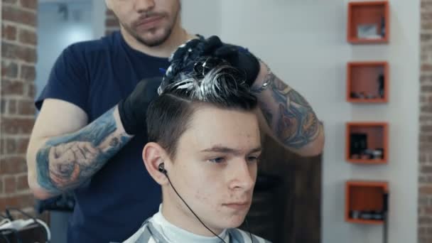 Gutaussehender Mann bekommt im Salon 4k eine Frisur. Straffung der Haare in blau. — Stockvideo