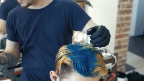 Coiffeur professionnel teignant les cheveux de sa cliente. Couleur de cheveux bleu . — Video