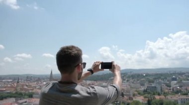 Erkek yolcu onun telefona Instagram veya diğer sosyal ağlar için eski şehrin panoramik bir fotoğraf olun. Romanya için seyahat.