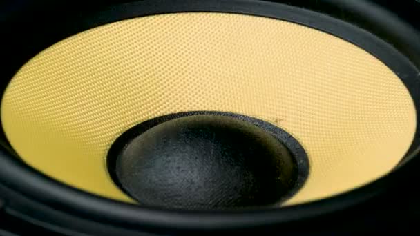 Gros plan sur le subwoofer en mouvement. Partie haut-parleur. Couleurs noir et jaune de la membrane. Concept d'instrument de musique. macro prise de vue vidéo . — Video