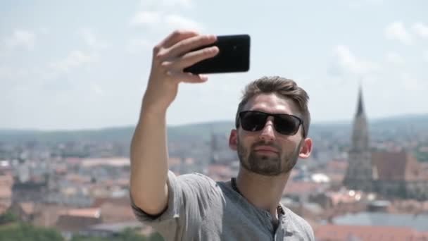Bello uomo barbuto fare selfie o fotografare telefono fotocamera atmosfera luci sullo sfondo. Un uomo con il telefono. Stile di vita. Copia spazio — Video Stock