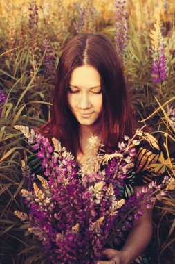 Portret genç kız lupines bir alana yakın çekim