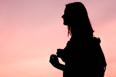 Kız güzel gökyüzü manzarası ile gün doğumu sahiptir. Profel portre.