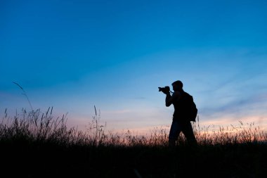 Seyahat etmeyi sever bir genç ve fotoğrafçı, gündoğumu günbatımı, güzel anlarda fotoğraflarını siluet.