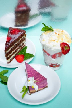 Lezzetli taze pişmiş çörekler ve turkuaz arka plan üzerinde renkli şekerler.