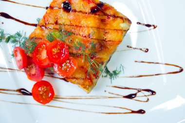 Lazanya beyaz tabakta domates ile