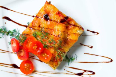 Lazanya beyaz tabakta domates ile