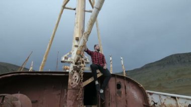 Erkek turist deniz ya da okyanus terk edilmiş bir gemide bakarak. Macera ve Turizm kavramı.