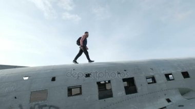 İzlanda'daki Vik yakınındaki Solheimasandur sahilde terk edilmiş eski uçak düştü üzerinde yürüyen adam