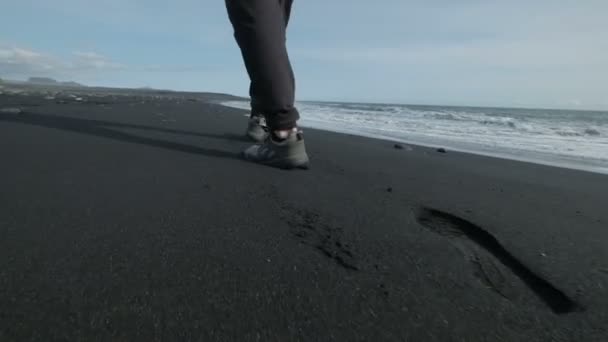 Jonge, knappe man loopt op het zand van de zee. — Stockvideo