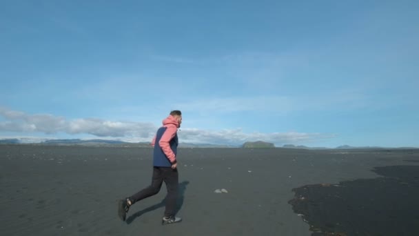 Joven y guapo hombre corriendo sobre la arena del mar . — Vídeo de stock