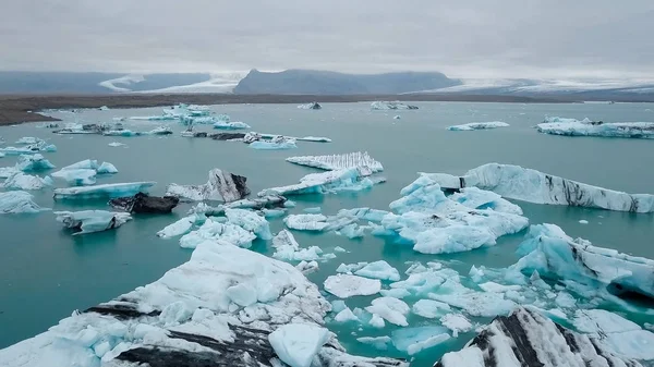 Aéreo sobre icebergs flutuando na Lagoa Jokulsarlon pela costa sul da Islândia — Fotografia de Stock