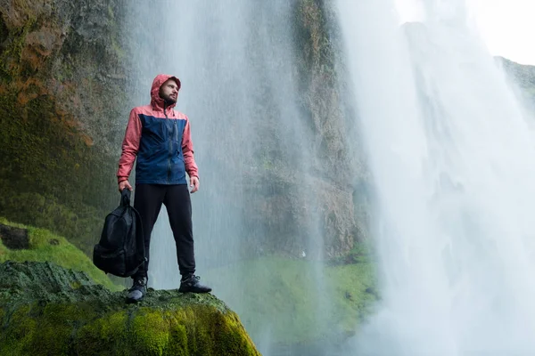 Skogafoss şelale, İzlanda doğa macera adam. Genç adam doğa manzara ziyaret. — Stok fotoğraf
