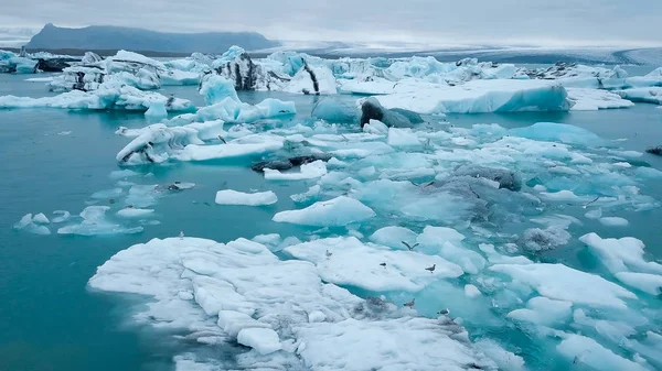 Aéreo sobre icebergs flutuando na Lagoa Jokulsarlon pela costa sul da Islândia — Fotografia de Stock