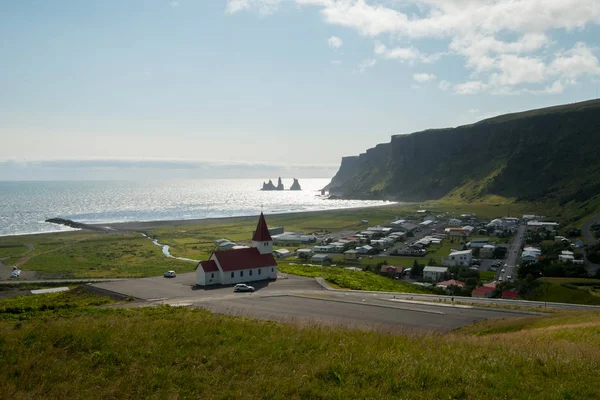 La vista della chiesa e della città di Viks, l'Islanda e la famosa spiaggia di sabbia nera . — Foto Stock