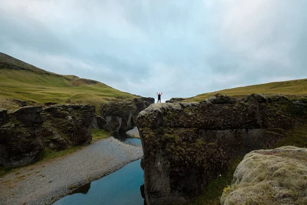 Muž stojí na kopci s rukama — Stock fotografie