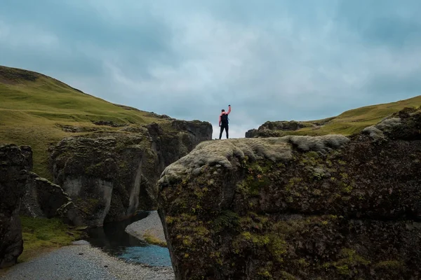 Muž stojí na kopci s rukama — Stock fotografie