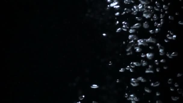 Burbujas sobre fondo negro. agua hirviendo de cerca — Vídeo de stock