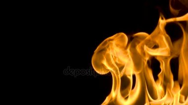 Yangın ve siyah bir arka plan ile yavaş çekimde bir yansıtıcı cam yüzey üzerinde yavaşça alevler ile yanan alevler