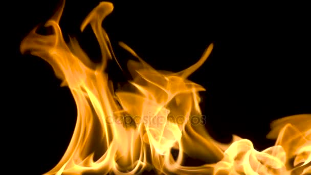 Feuer und Flammen brennen auf einer reflektierenden Glasoberfläche, in Zeitlupe mit schwarzem Hintergrund, wobei sich die Flammen langsam bewegen