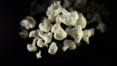 Karnabahar havada bir siyah arka plan üzerine düşüyor. ağır çekim.