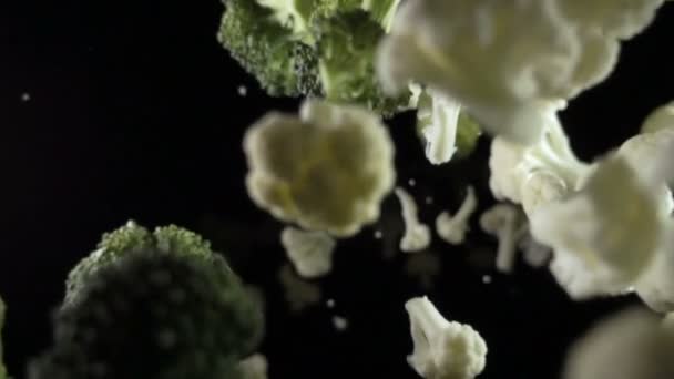 Blomkål faller i luften på en svart bakgrund. slowmotion. — Stockvideo