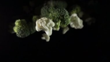 Karnabahar havada bir siyah arka plan üzerine düşüyor. ağır çekim.